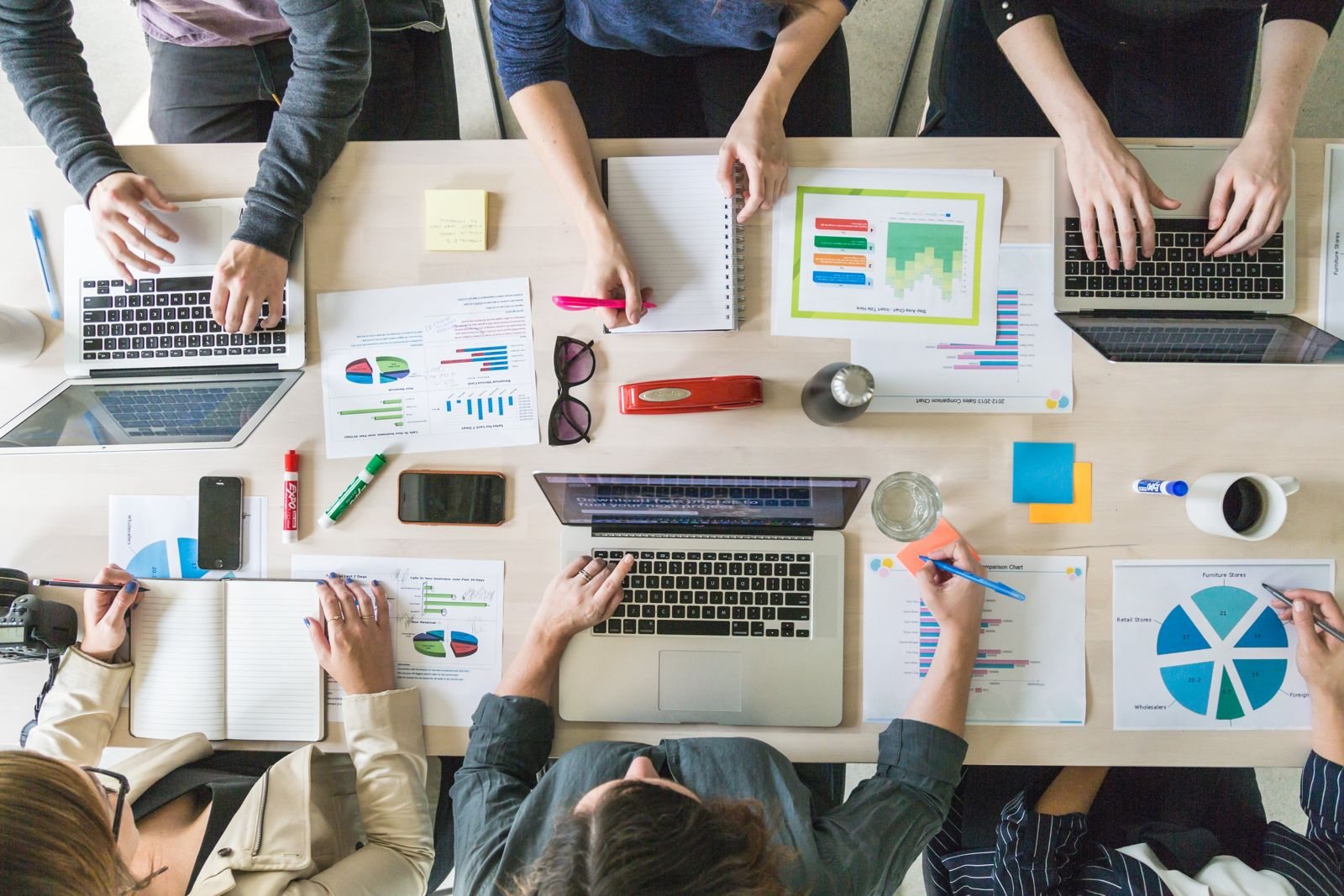 Vue de dessus d’une table de travail avec ordinateurs portables, carnets et documents